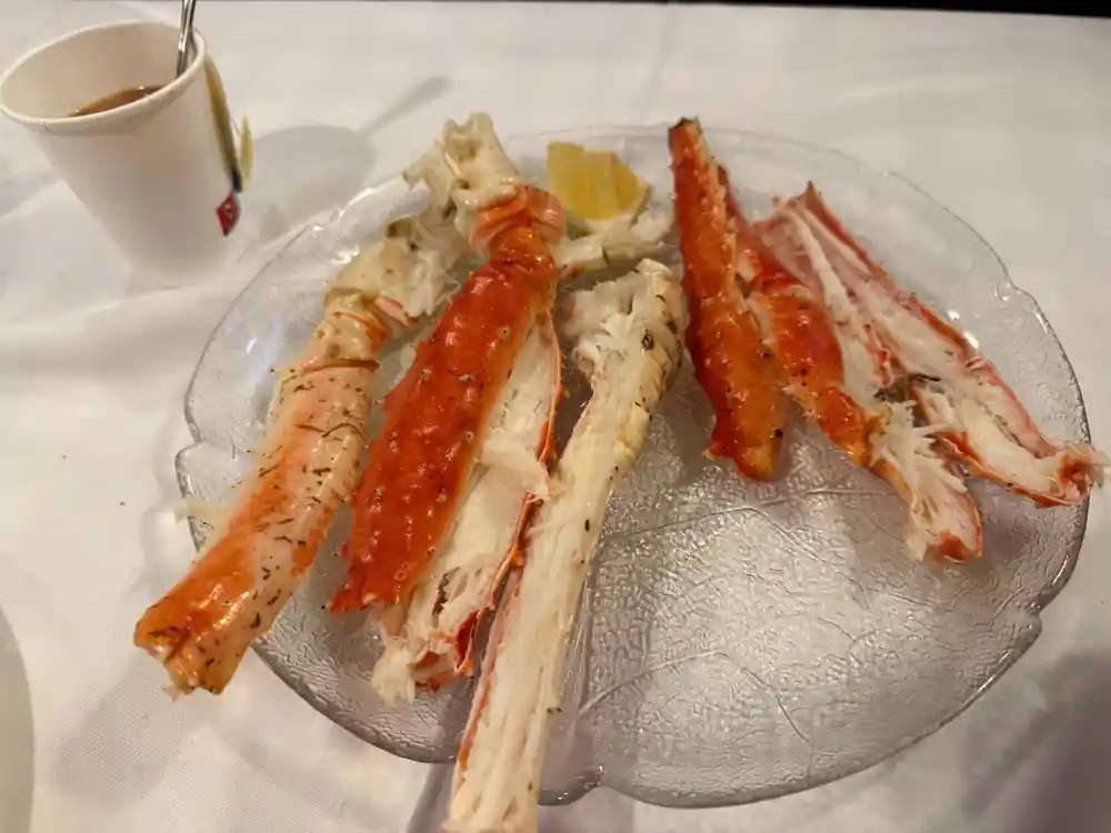 Cooked crab legs arranged on a glass plate with lemon