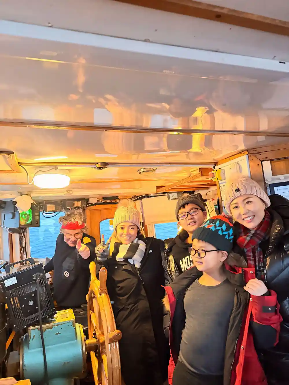 A group of guests posing together in the warm wheelhouse