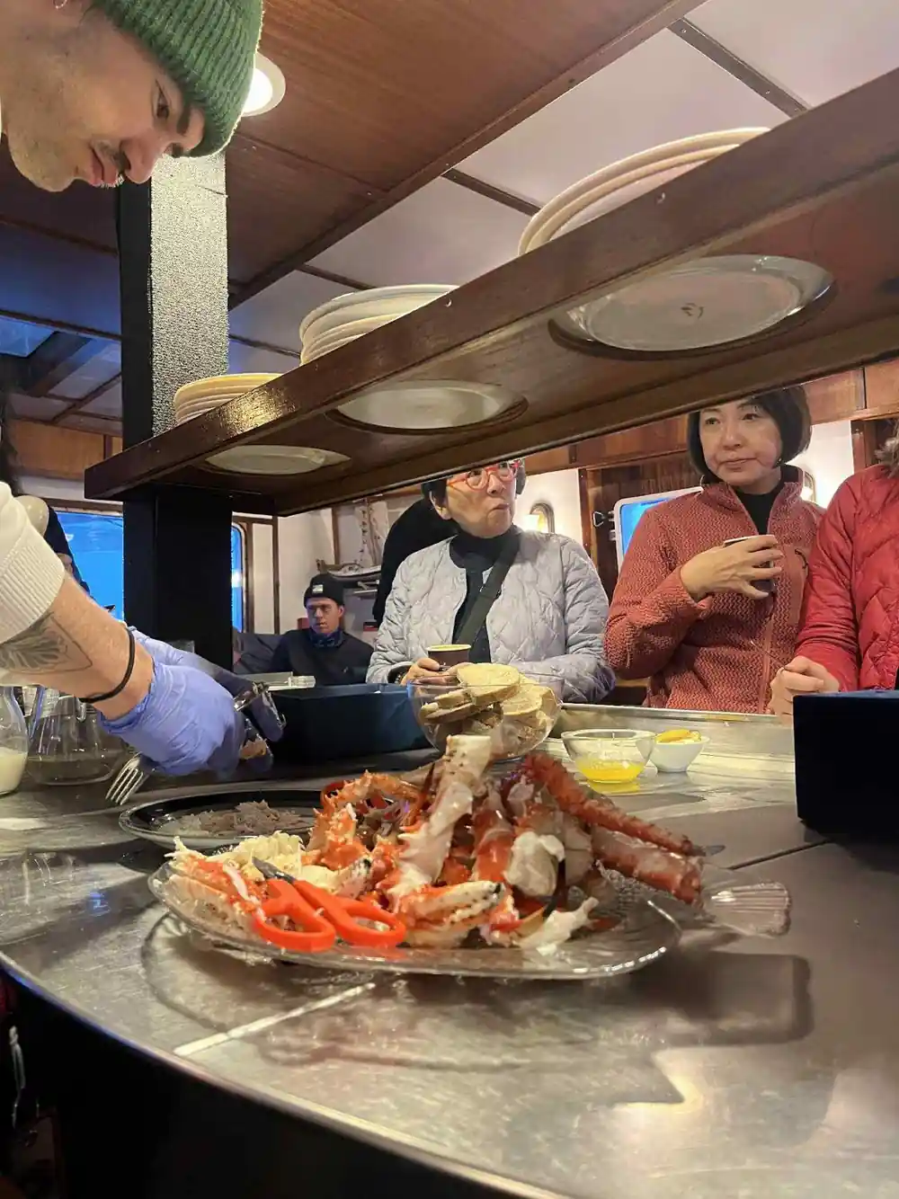Guests gathered around a platter of crab in the galley