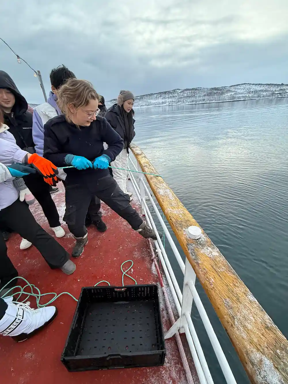 Guests at the rail working a line down into the water