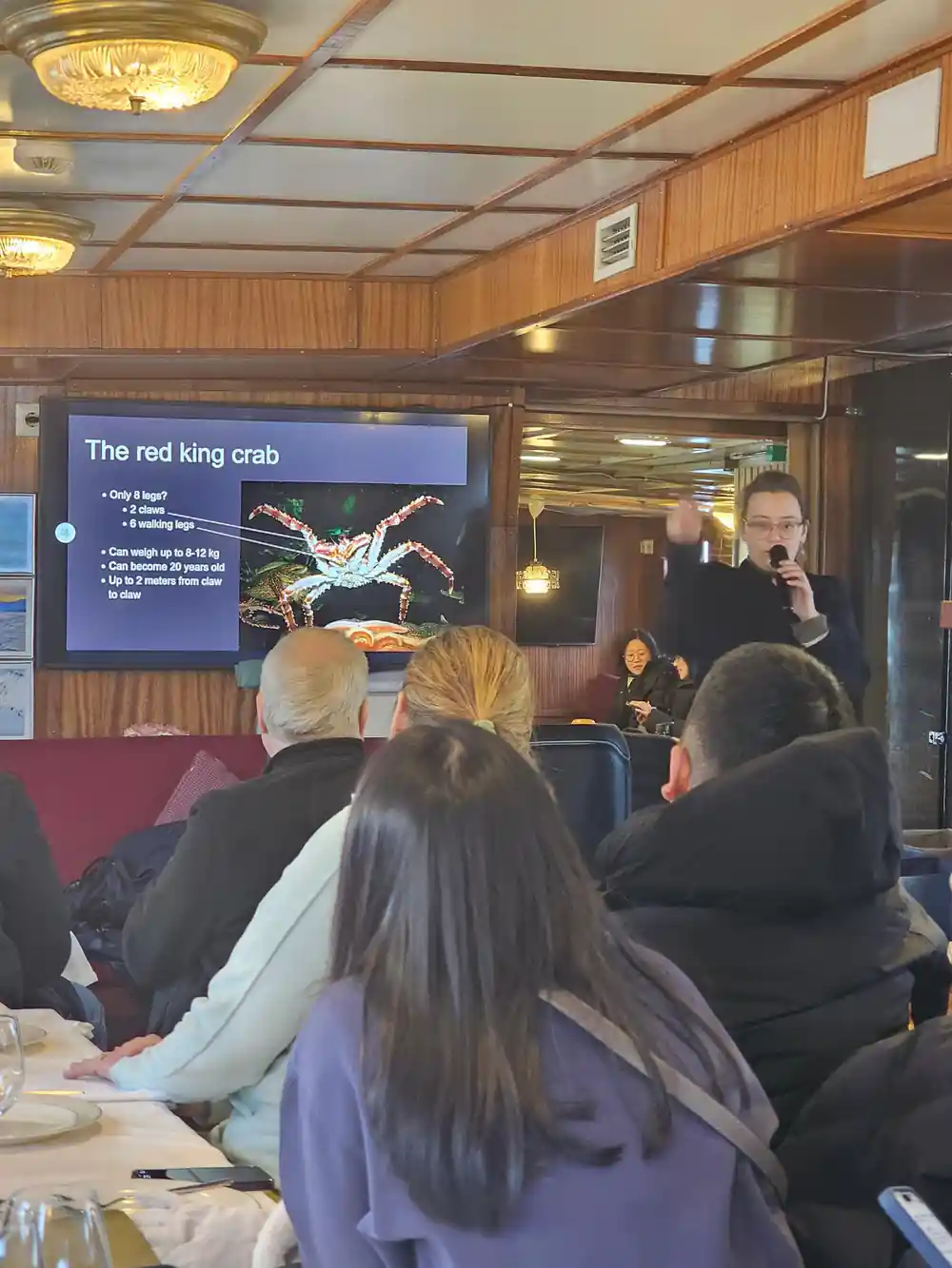 Guests watching a screen presentation about the red king crab