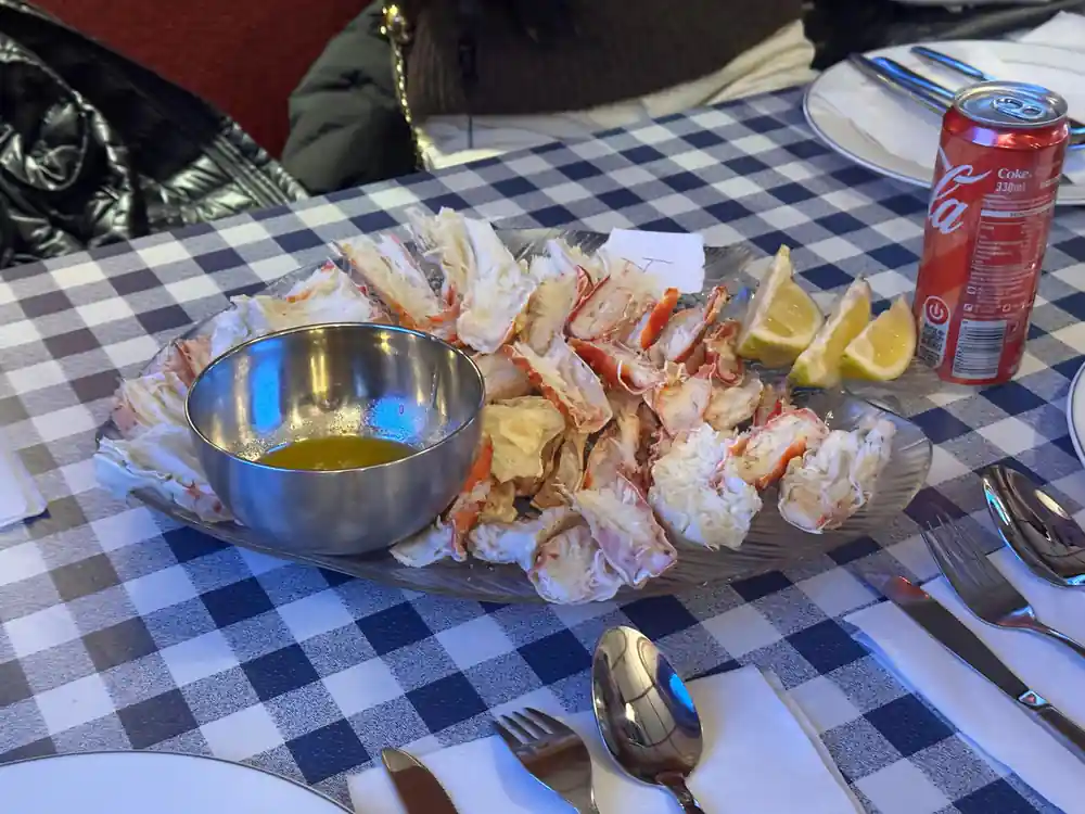 A laid table with a platter of crab and a bowl of butter