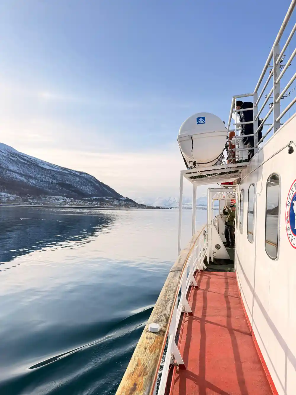 Looking forward along the red deck with snowy mountains ahead