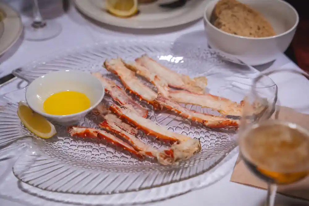 Plate of split king crab legs with melted butter and lemon