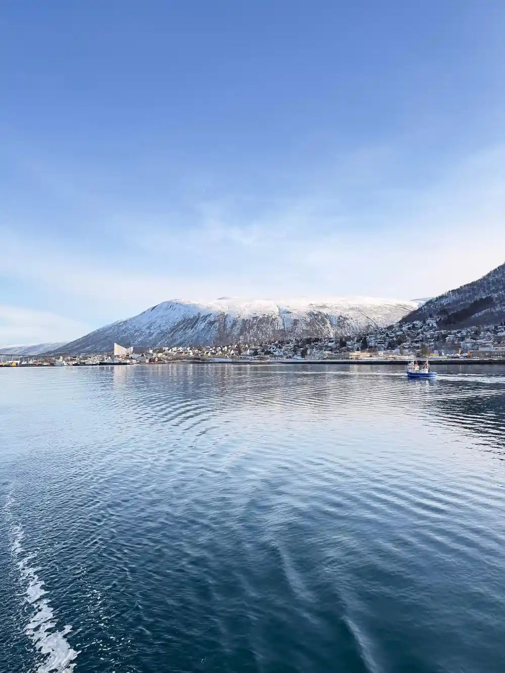 Snow-covered Tromso shoreline and mountains seen across the water