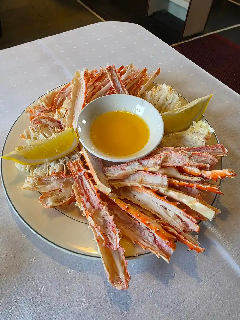 Split crab legs fanned on a plate with butter and lemon